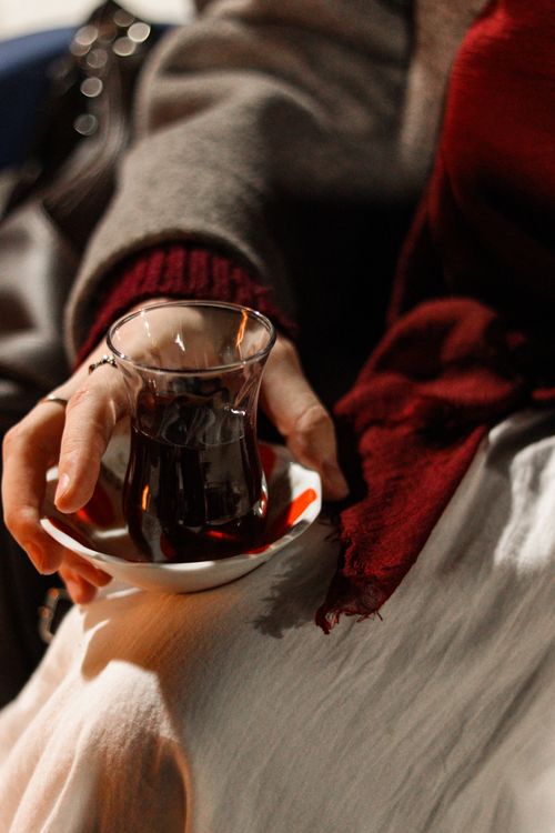 Free Warm and cozy scene of a person holding traditional Turkish tea, wrapped in a scarf. Stock Photo
