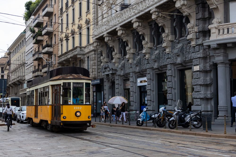 Tramvai galben trecând pe o stradă istorică din Milano