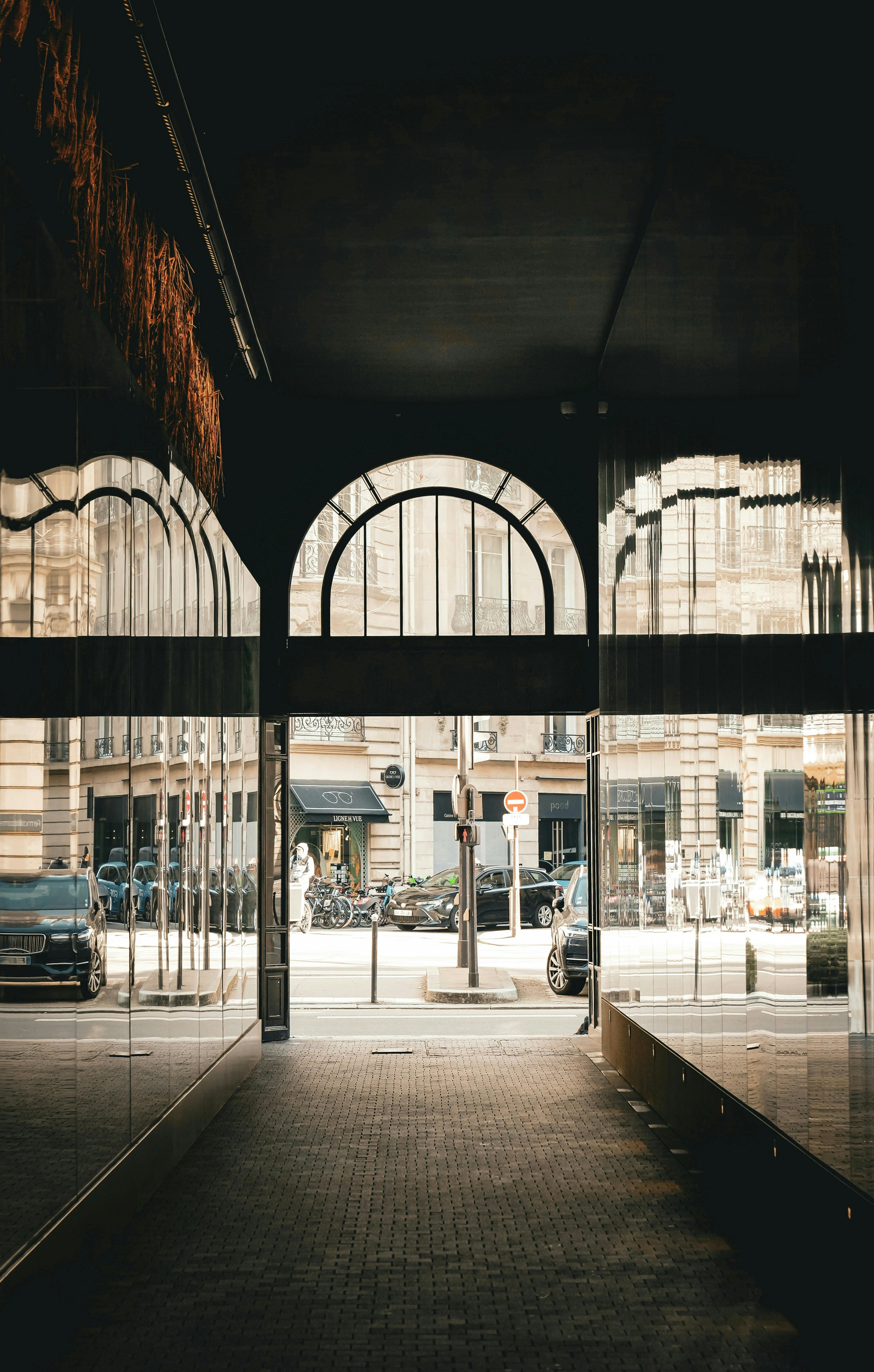 Gratuit O scenă urbană sumbră din Paris, cu o arcadă din secolul al XIX-lea și reflexii ale unei clădiri. Fotografie de stoc