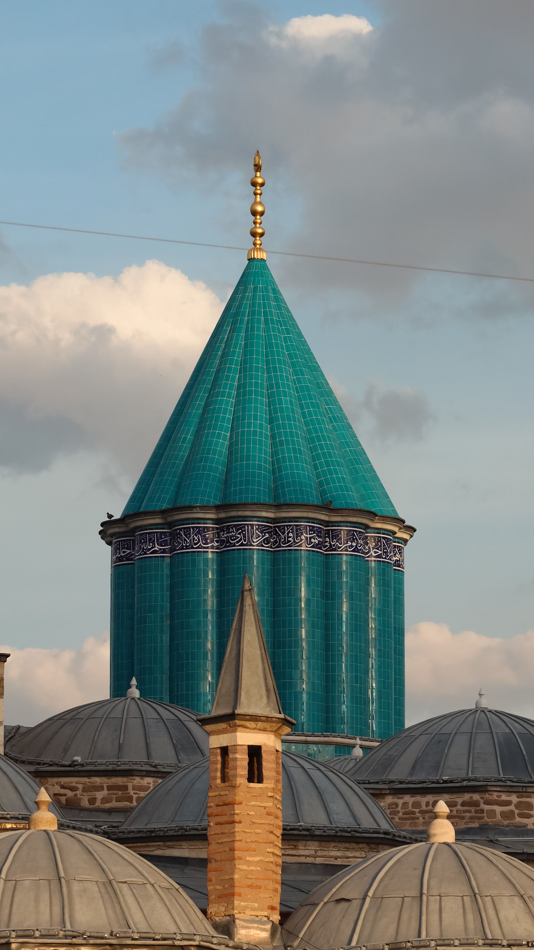 Stunning turquoise dome of Mevlana Mosque under blue skies in Konya, Türkiye.