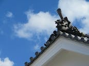Traditional Japanese Onigawara Roof Ornament Against Blue Sky