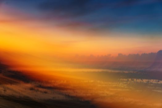 A mesmerizing abstract scene of a vibrant sunset with blurred colors merging into the horizon.