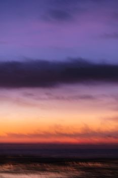 A serene view of a colorful twilight sunset over the ocean with a gradient sky.