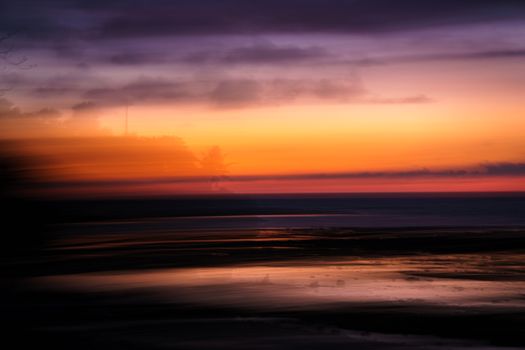 Abstract ocean sunset with vibrant colors and smooth horizon line creating a dreamy seascape.