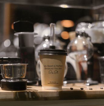 A stylish coffee cup with brewing tools in an artisan cafe setting.