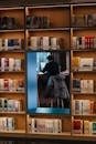 Man Reading in Library Surrounded by Bookshelves