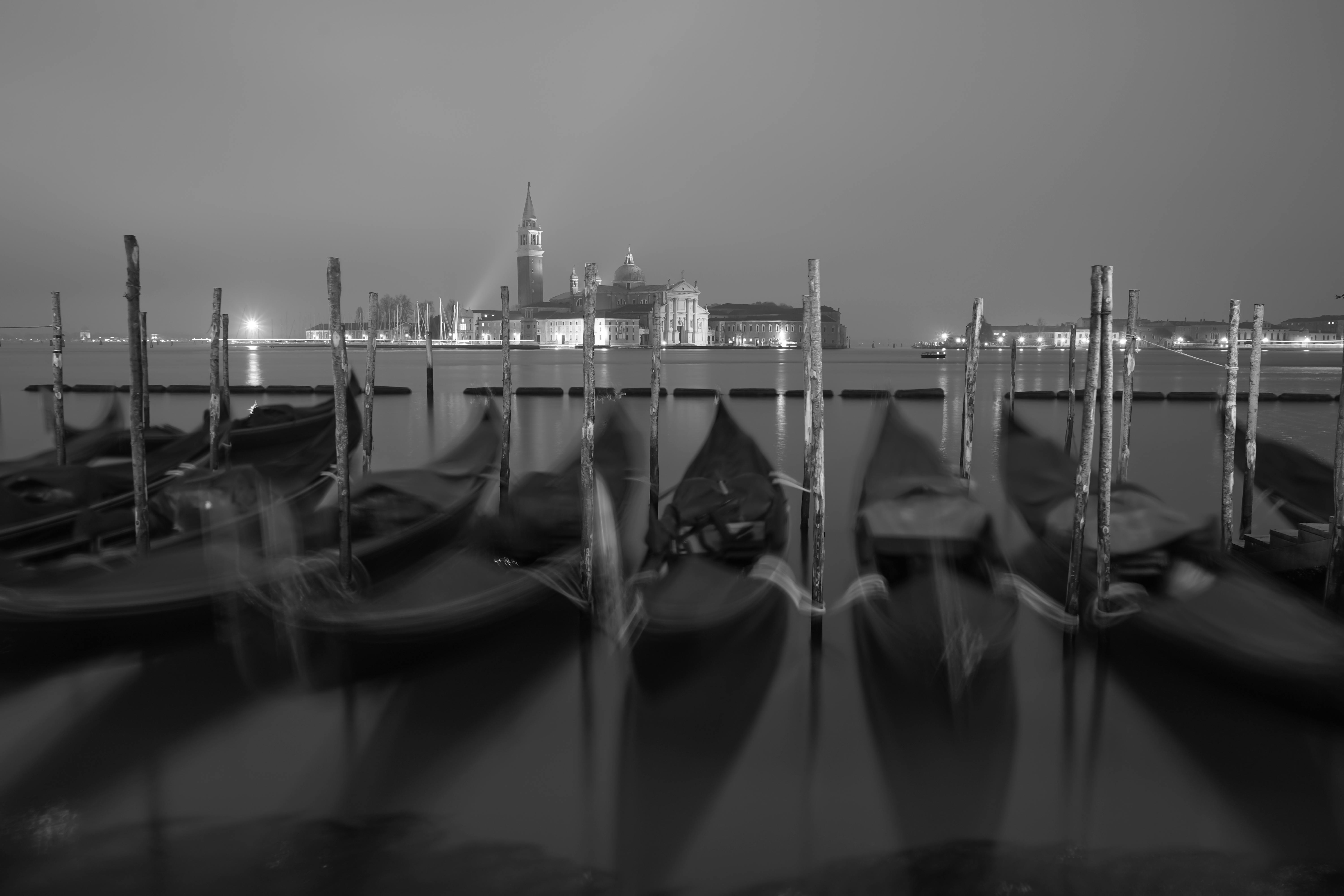 免费 威尼斯夜景中圣乔治马焦雷岛的贡多拉黑白照片。 素材图片