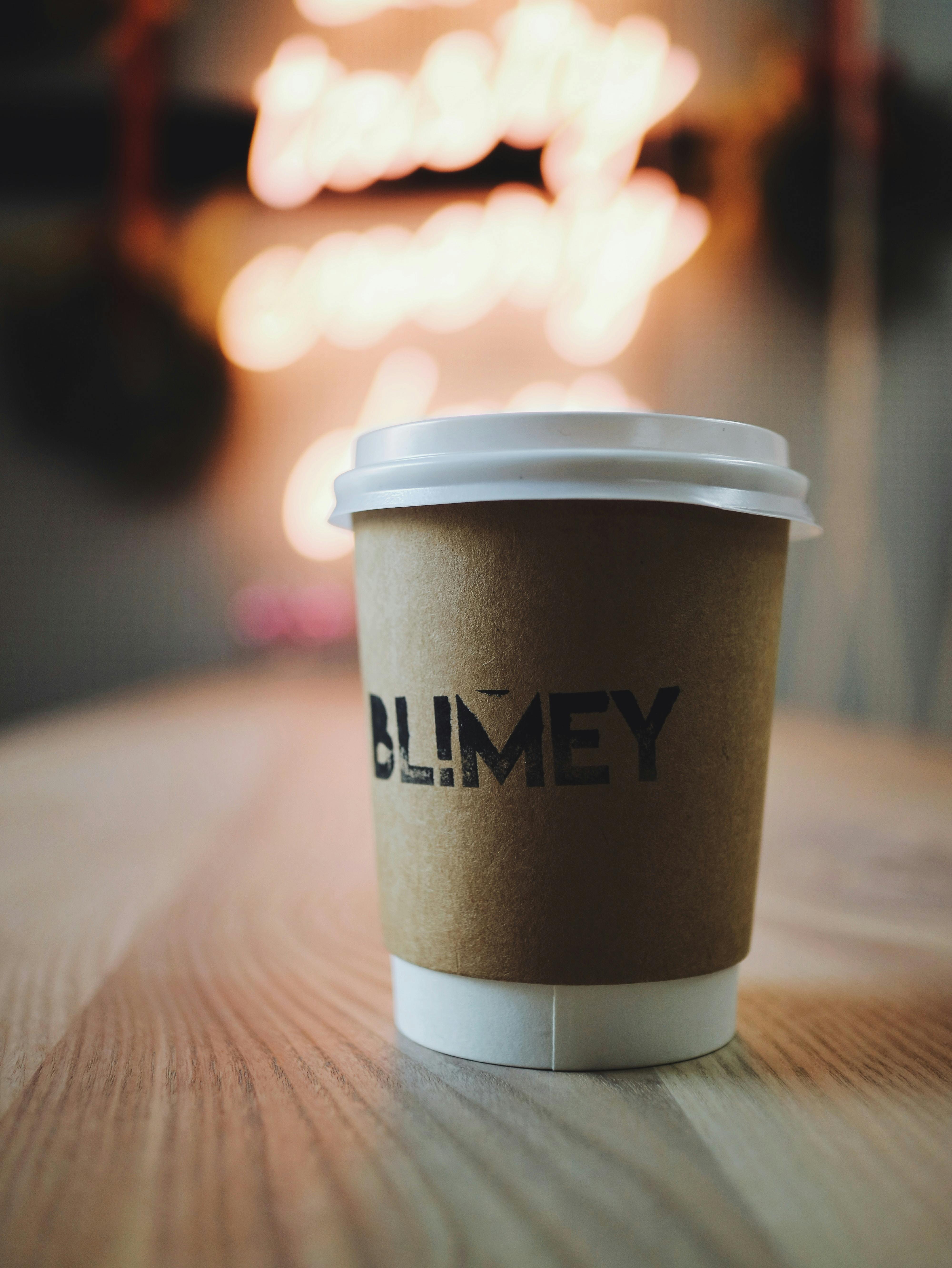Coffee cup with neon background on wooden table, perfect for cafe vibes.