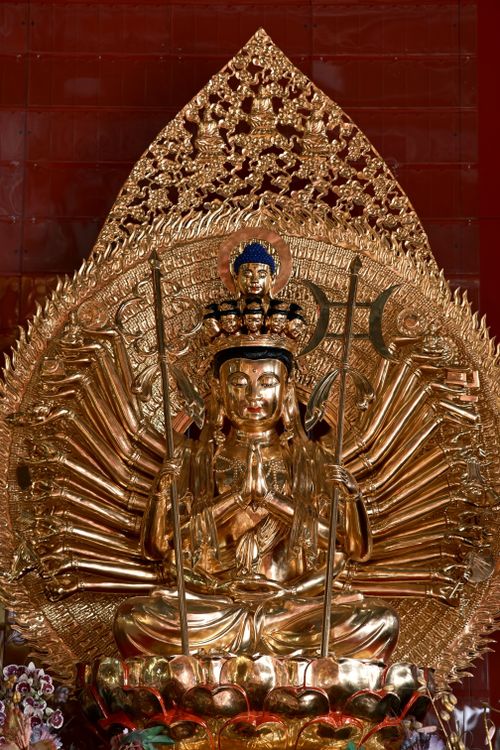 Free A magnificent golden statue of Avalokiteshvara Bodhisattva with multiple arms and intricate ornate details. Stock Photo