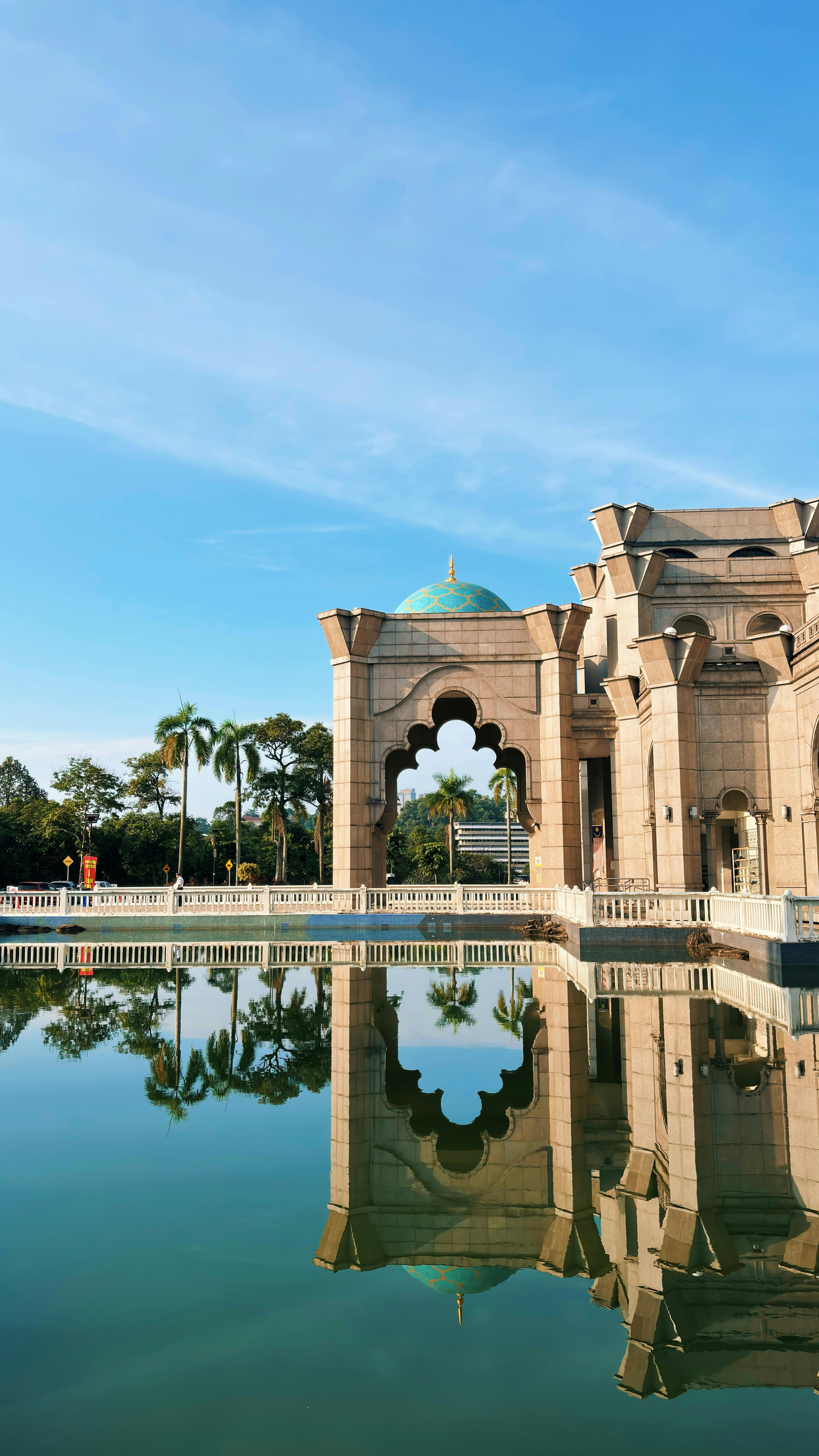 Stunning view of mosque reflection in Kuala Lumpur, Malaysia, under a clear blue sky.