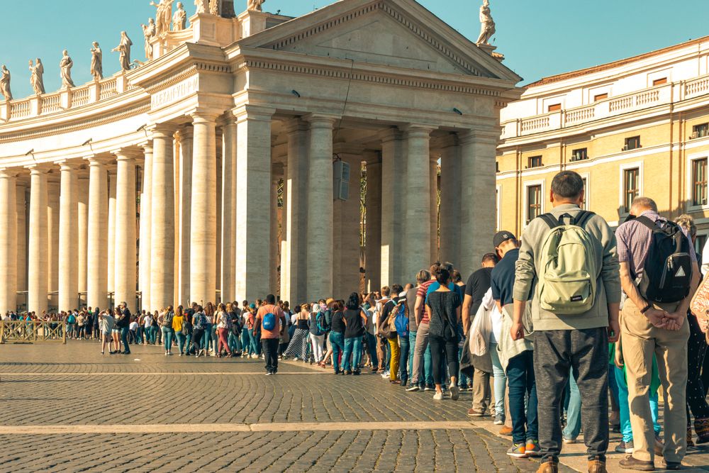 Coadă lungă de turiști de-a lungul colonadei din Piața San Pietro