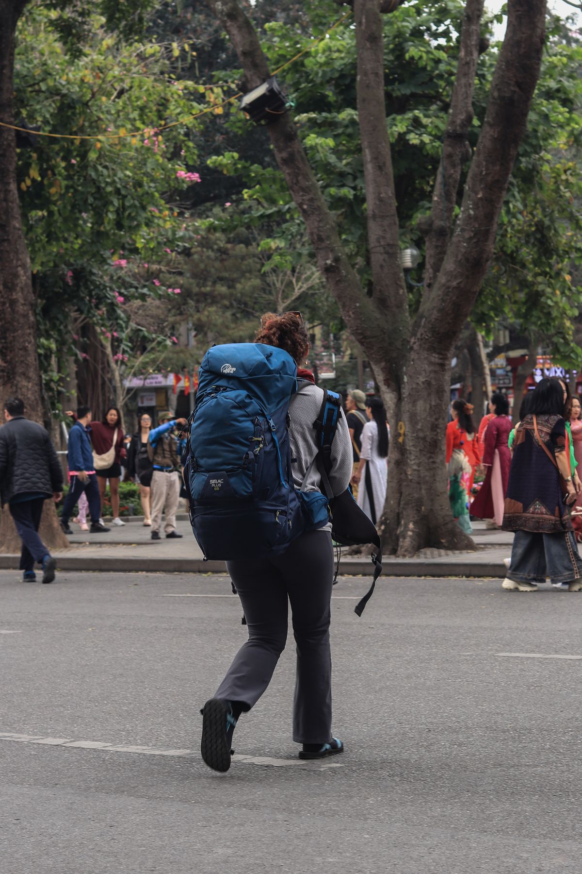 Backpacker walking through a vibrant city street with a travel backpack