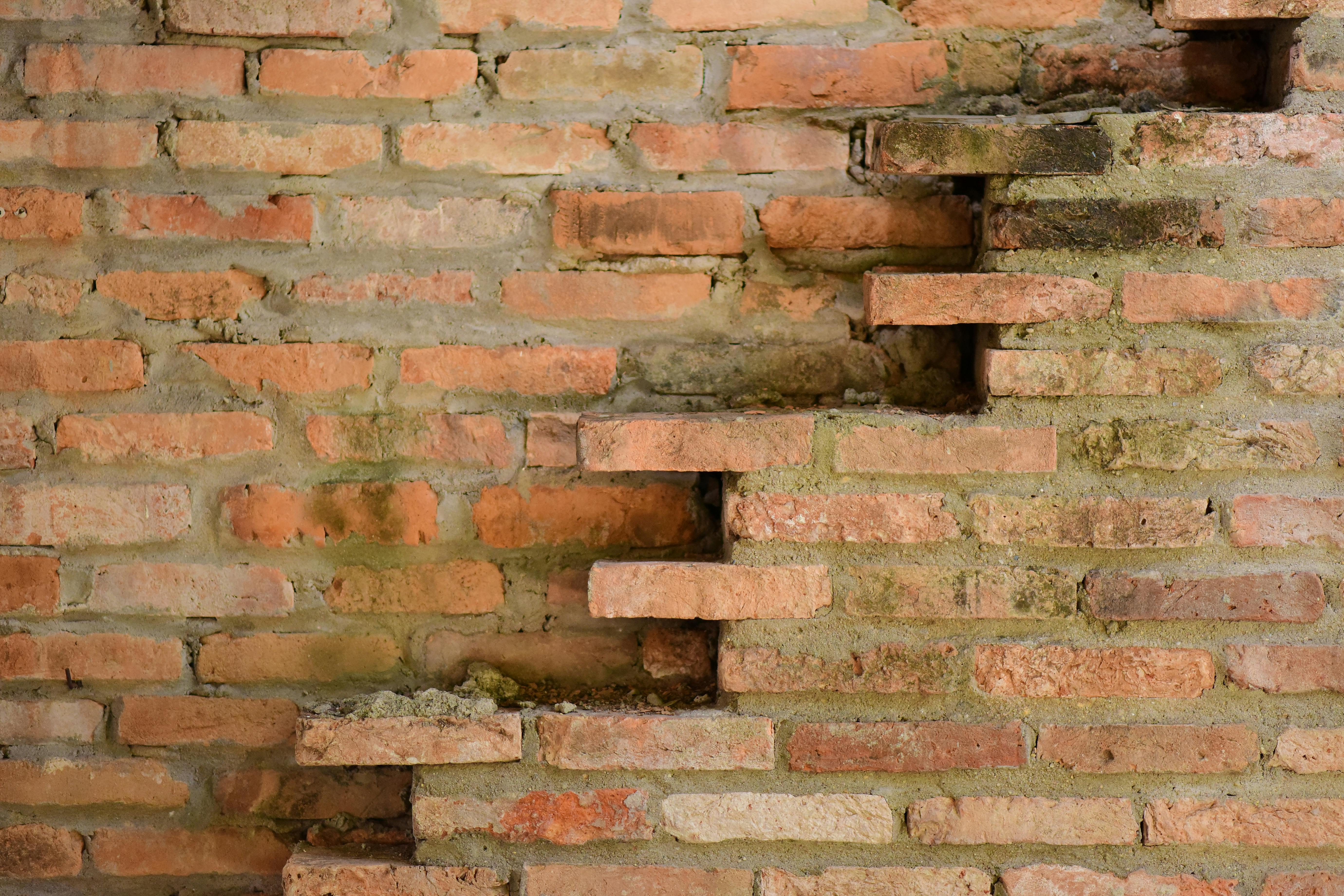 De franc Una vista detallada d'una antiga paret de maó desgastada que mostra colors i textures naturals. Foto d'estoc