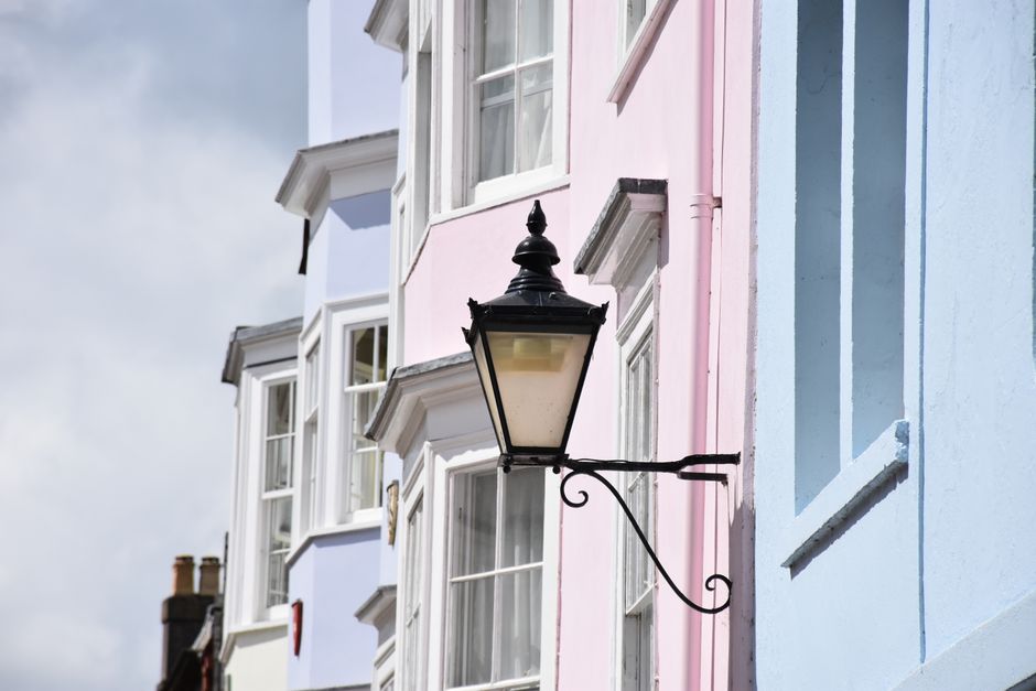 Pastel-colored building facades and vintage street lamp in Oxford, England.