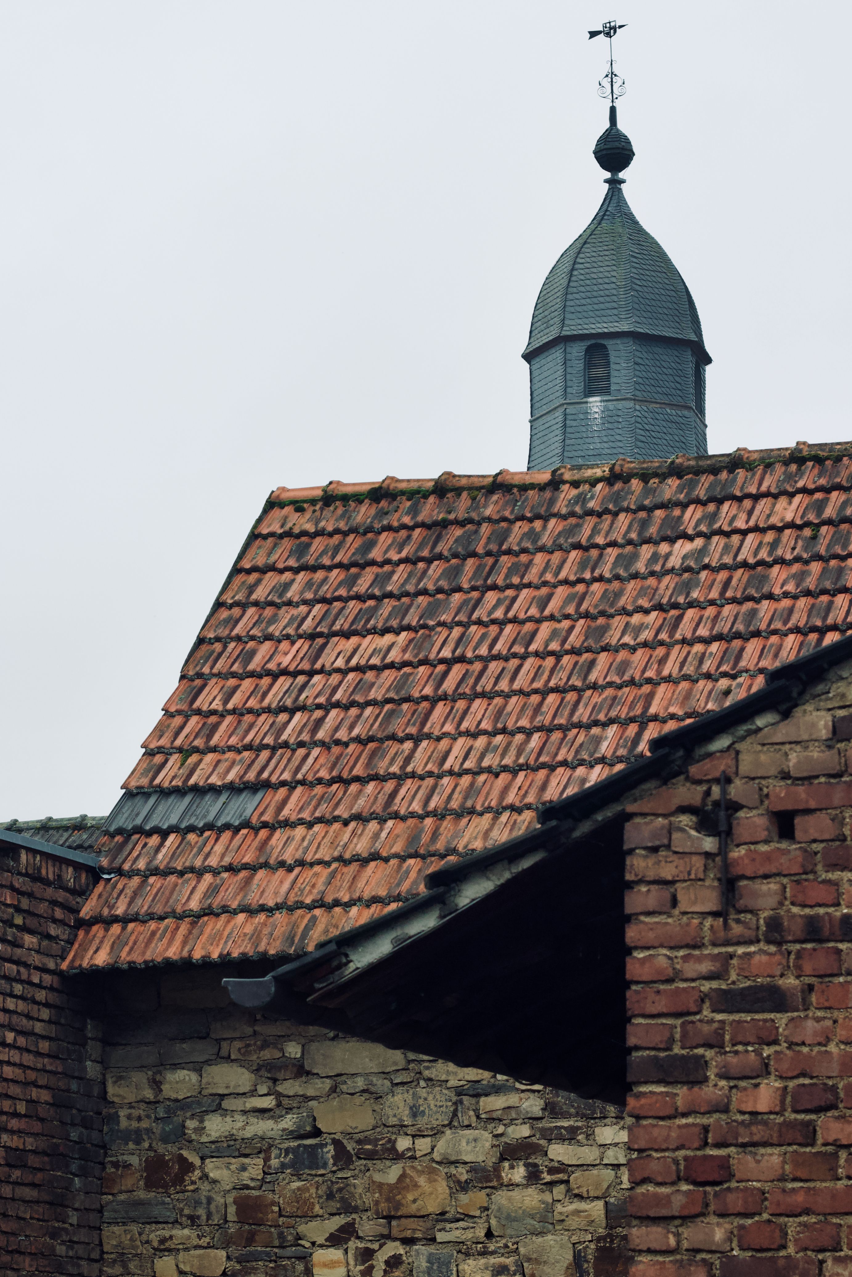 Historic Brick Building with Tiled Roof and Bell Tower · Free Stock Photo