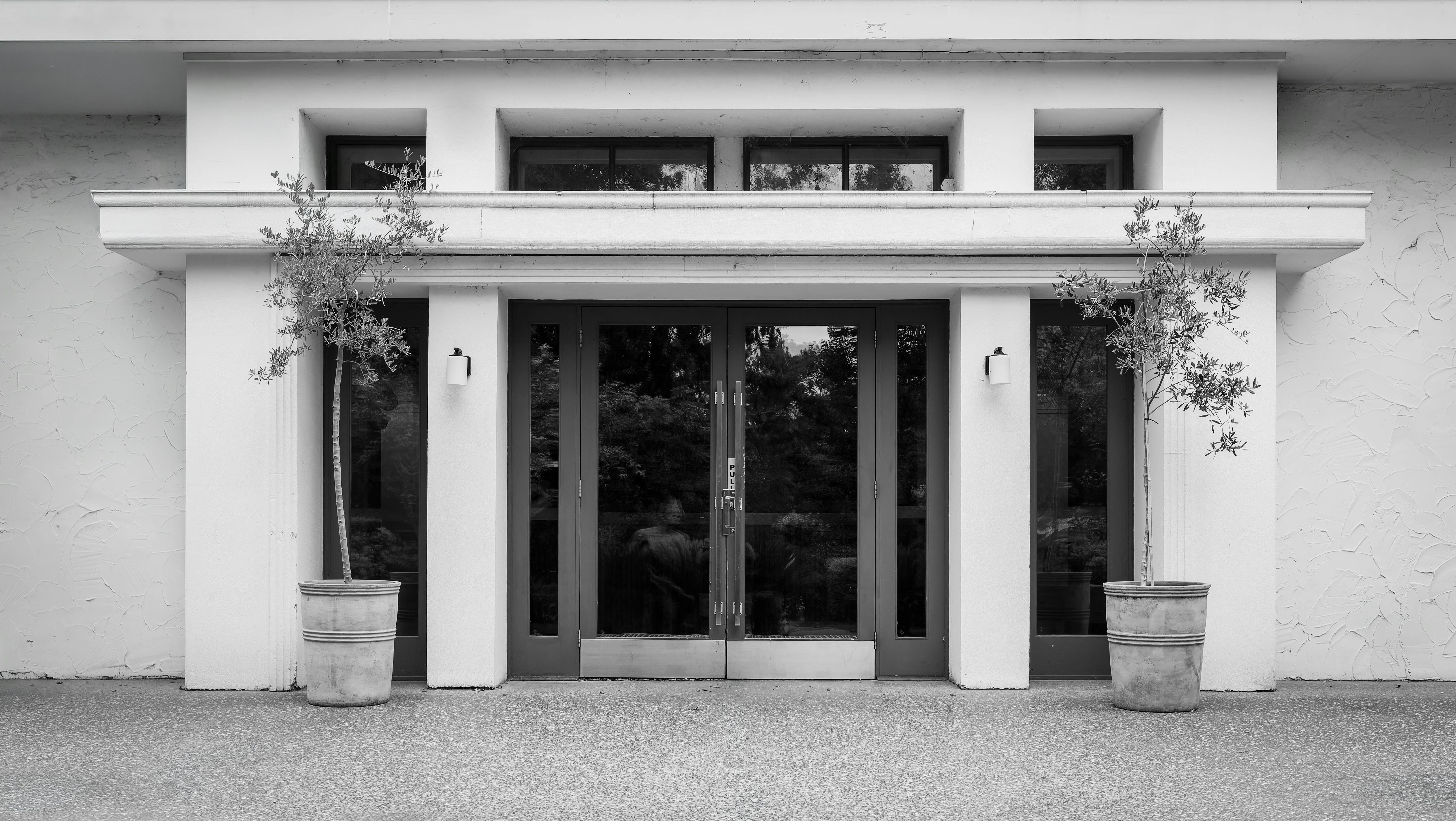 Gratuit Fațadă minimalistă alb-negru a unei intrări moderne cu plante în ghiveci. Fotografie de stoc