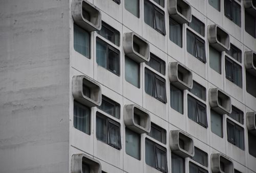 Free Detailed view of a modern building facade with unique window designs in Manchester, England. Stock Photo