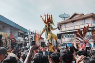 Vibrant traditional festival parade in Singkawang, West Kalimantan, featuring colorful costumes and crowd.