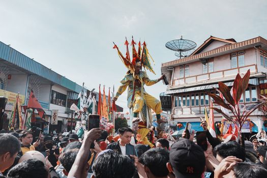 Vibrant traditional festival parade in Singkawang, West Kalimantan, featuring colorful costumes and crowd.