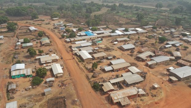 Aerial shot of a rural village in Africa with dirt roads and modest homes.
