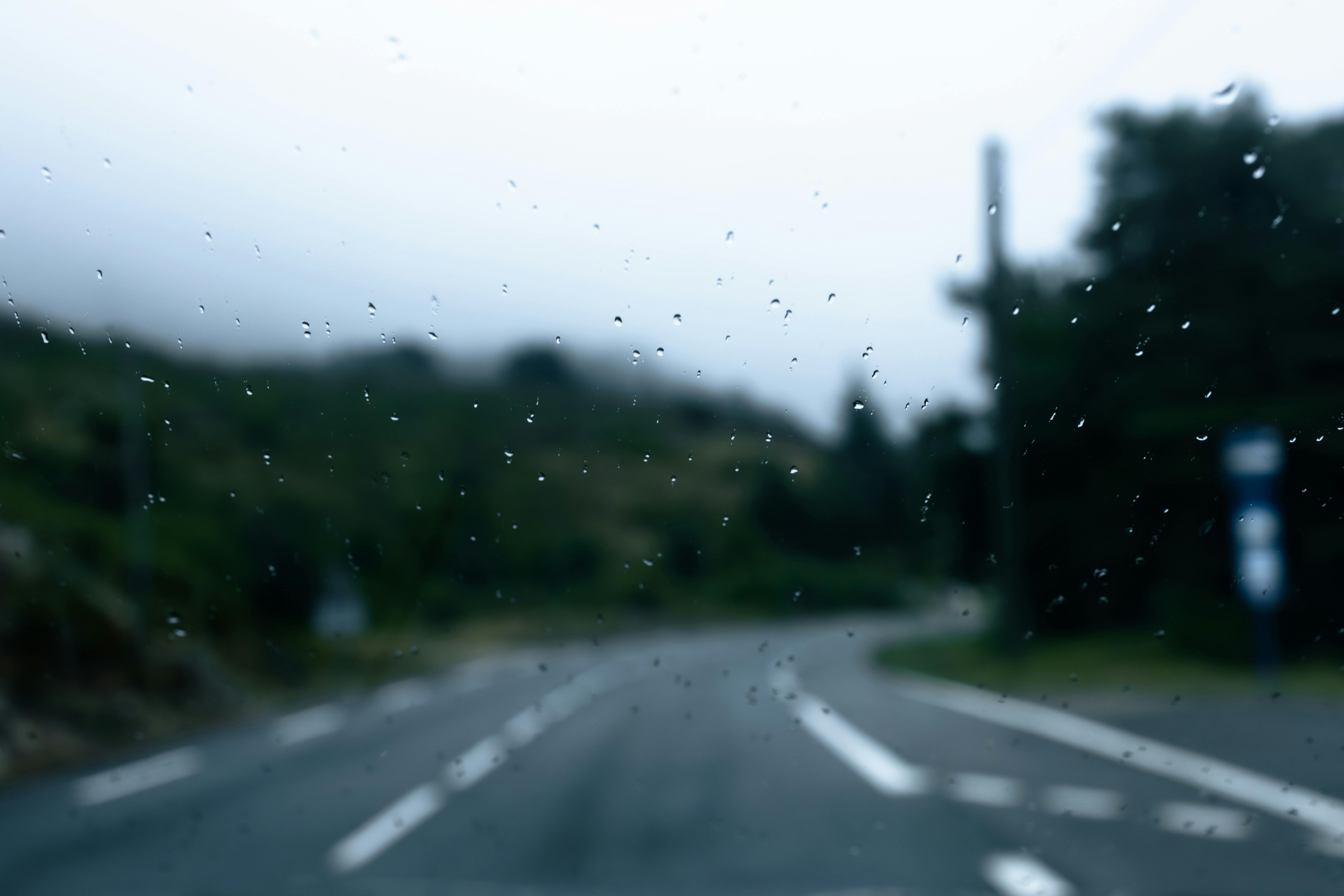 Free Blurred view of a rainy road in Provence, France, with mountains in the background. Stock Photo