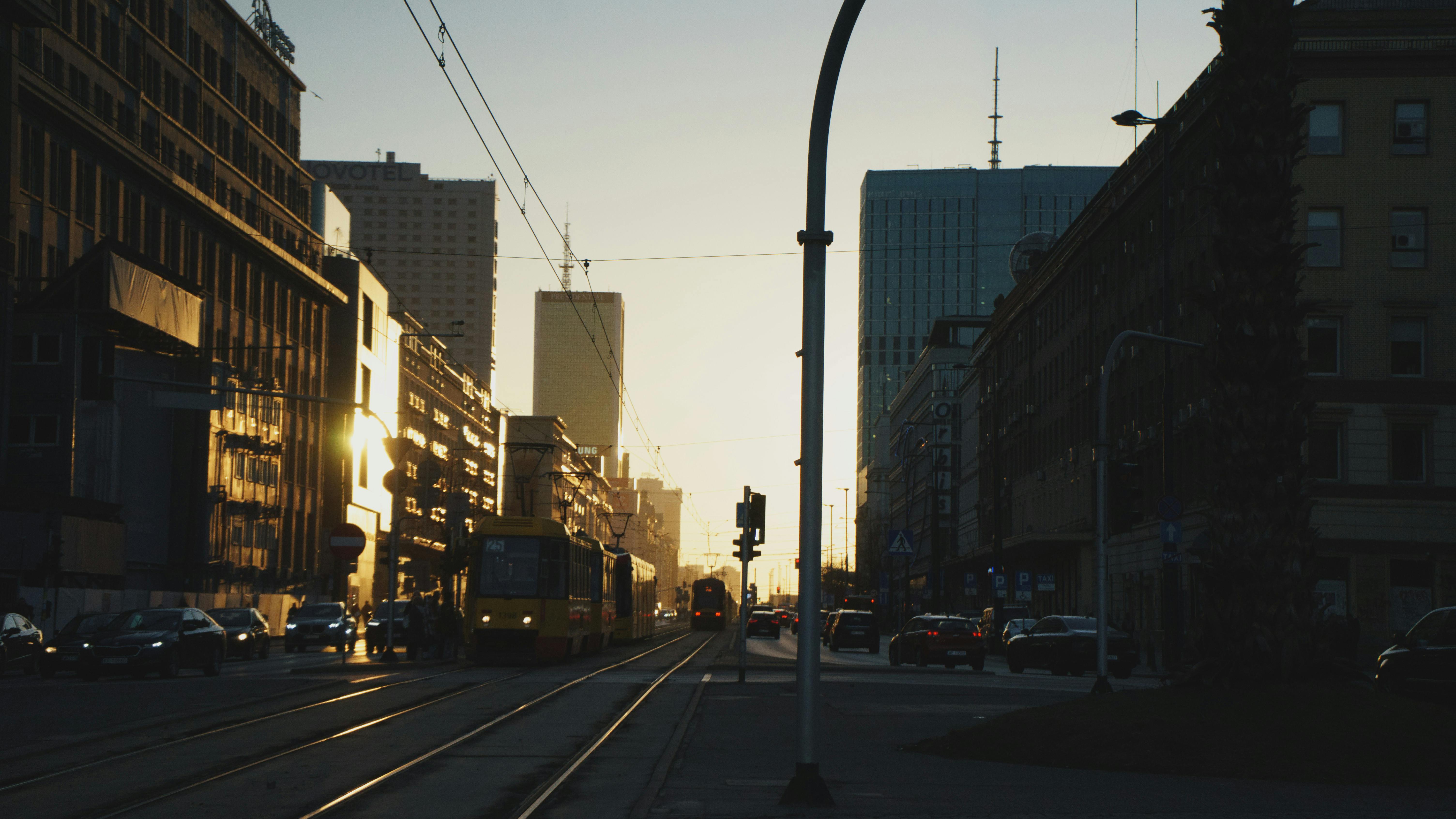 Ücretsiz Varşova şehir merkezinin üzerinde büyüleyici bir gün batımı, binaların silüetini ve geçen bir tramvayı gözler önüne seriyor. Stok Fotoğraflar