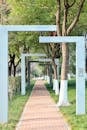 Serene Tree-Lined Pathway with Modern Arches