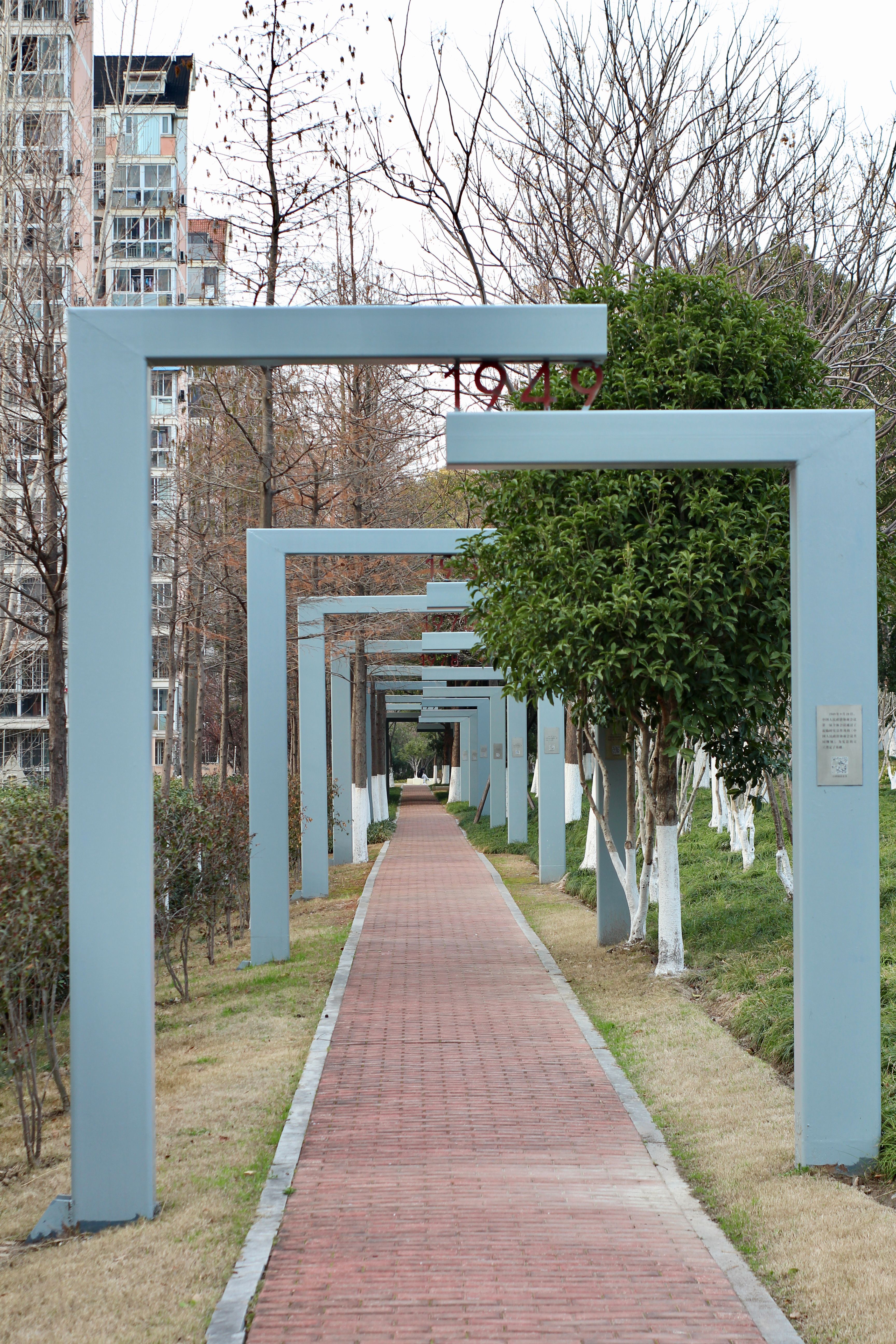 Modern Pathway with Steel Arches and Brick Walkway · Free Stock Photo