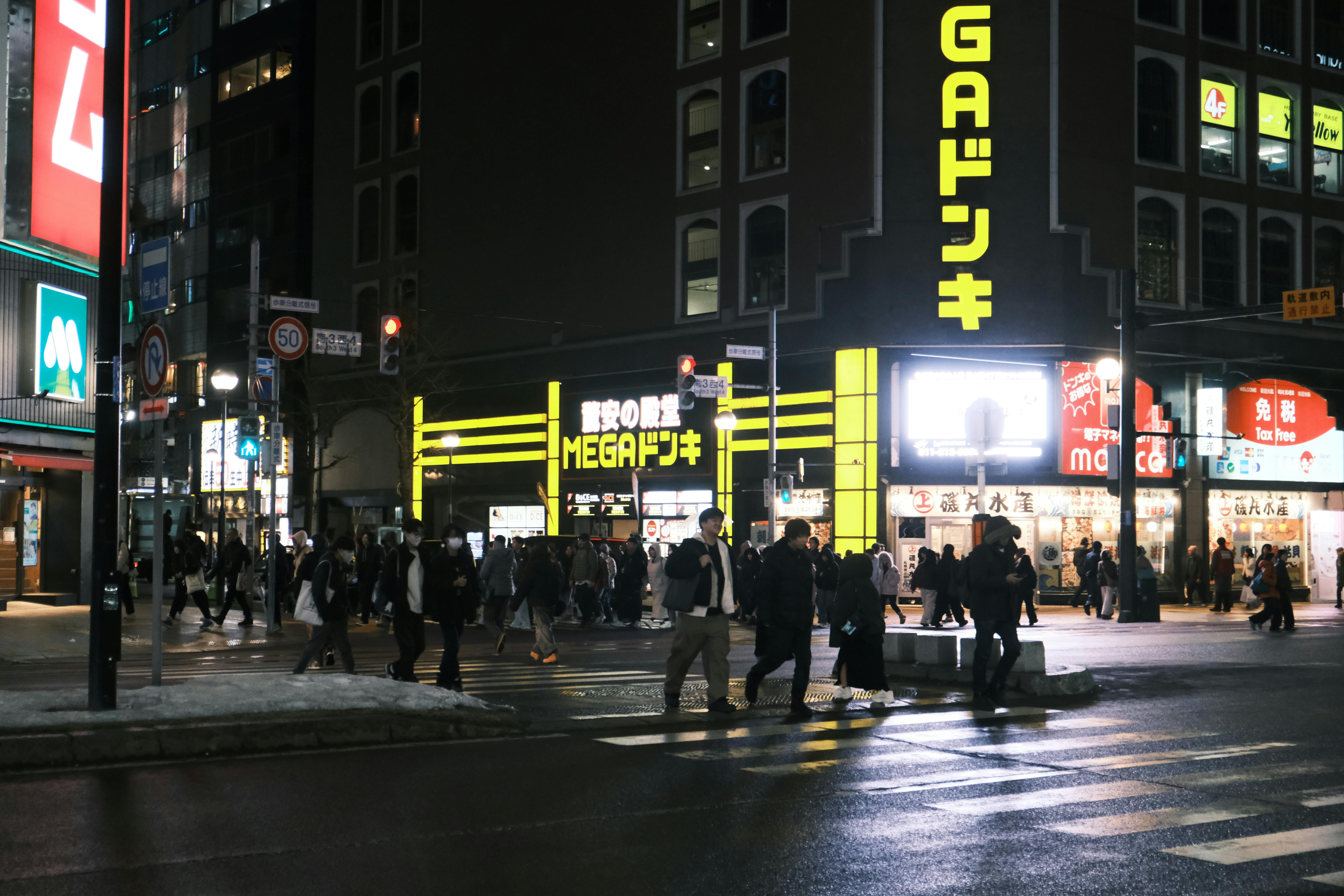Kostenlos Lebhaftes nächtliches Straßenbild in Sapporo, Hokkaido, mit Neonlichtern und Fußgängern. Stock-Foto