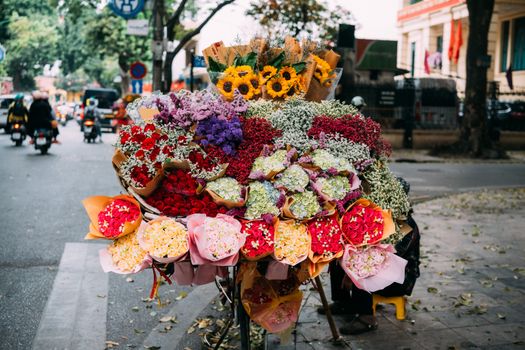 Colorful flower stall with diverse floral bouquets on a street in Hanoi, Vietnam.