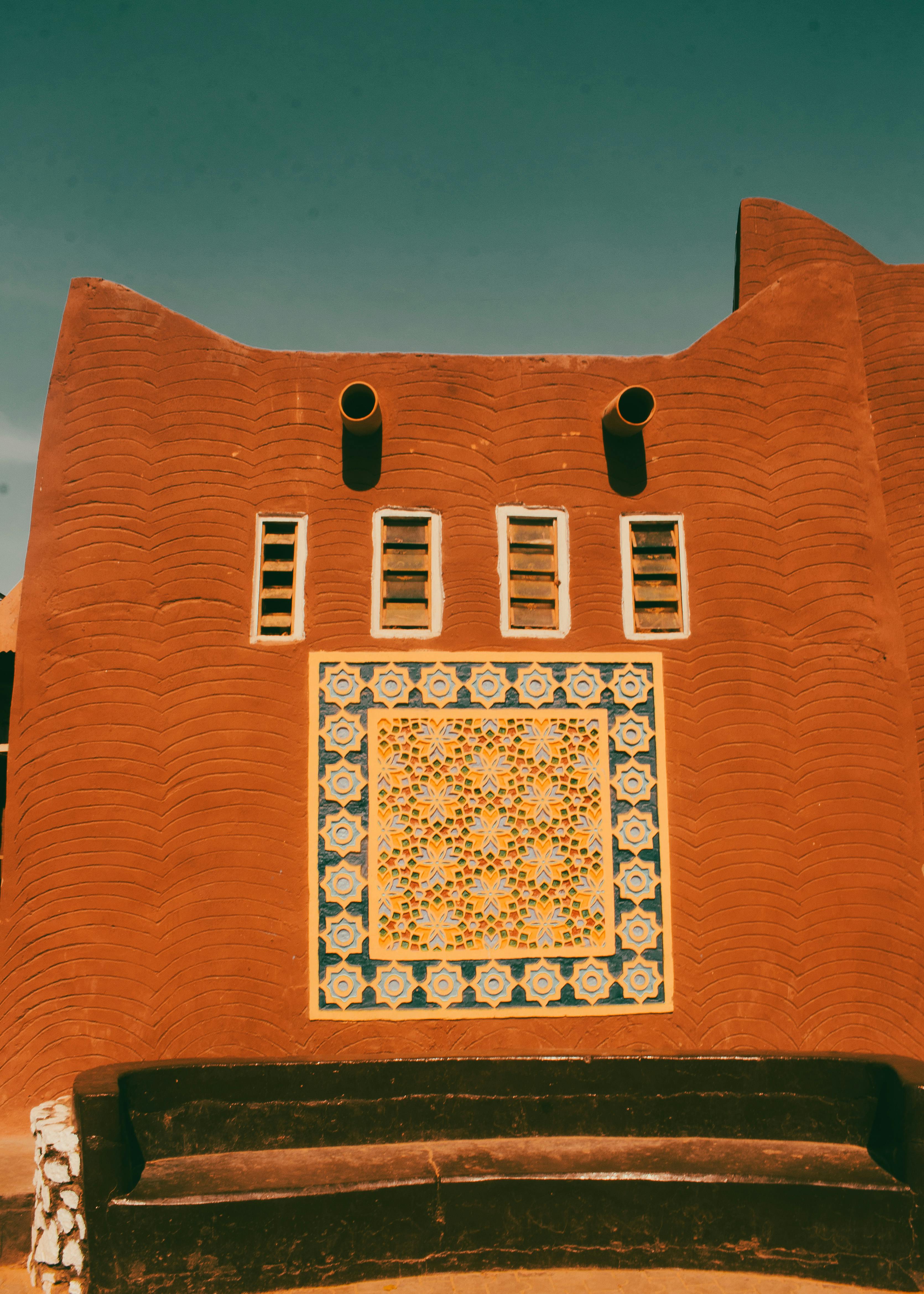 Kostenlos Charmante Architektur aus dem Nahen Osten mit dekorativen Mosaiken auf einer Lehmziegelwand – eine Mischung aus Tradition und Kunst. Stock-Foto