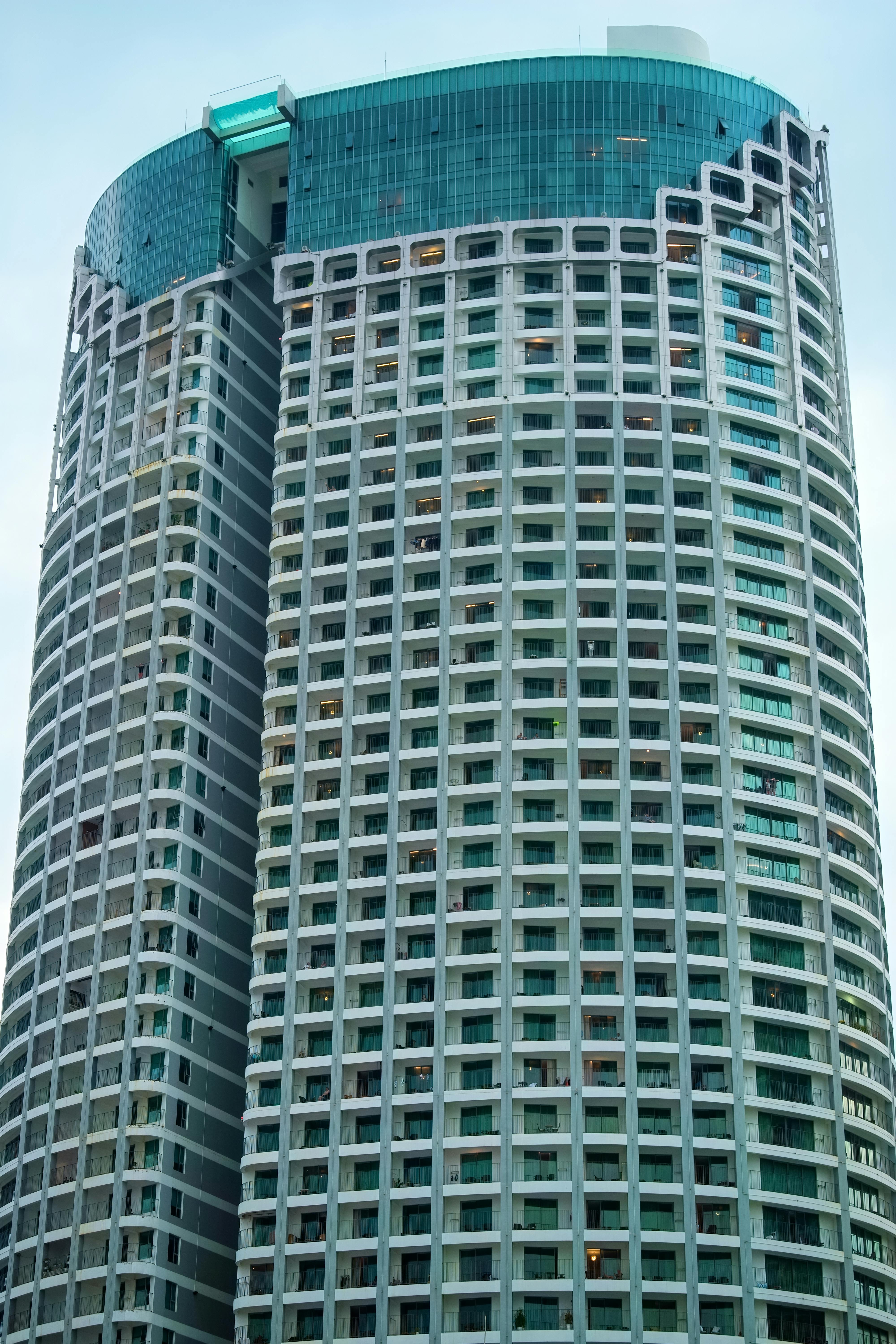 gratis Een indrukwekkende moderne wolkenkrabber met een uniek architectonisch ontwerp in een stedelijke omgeving. Stockfoto