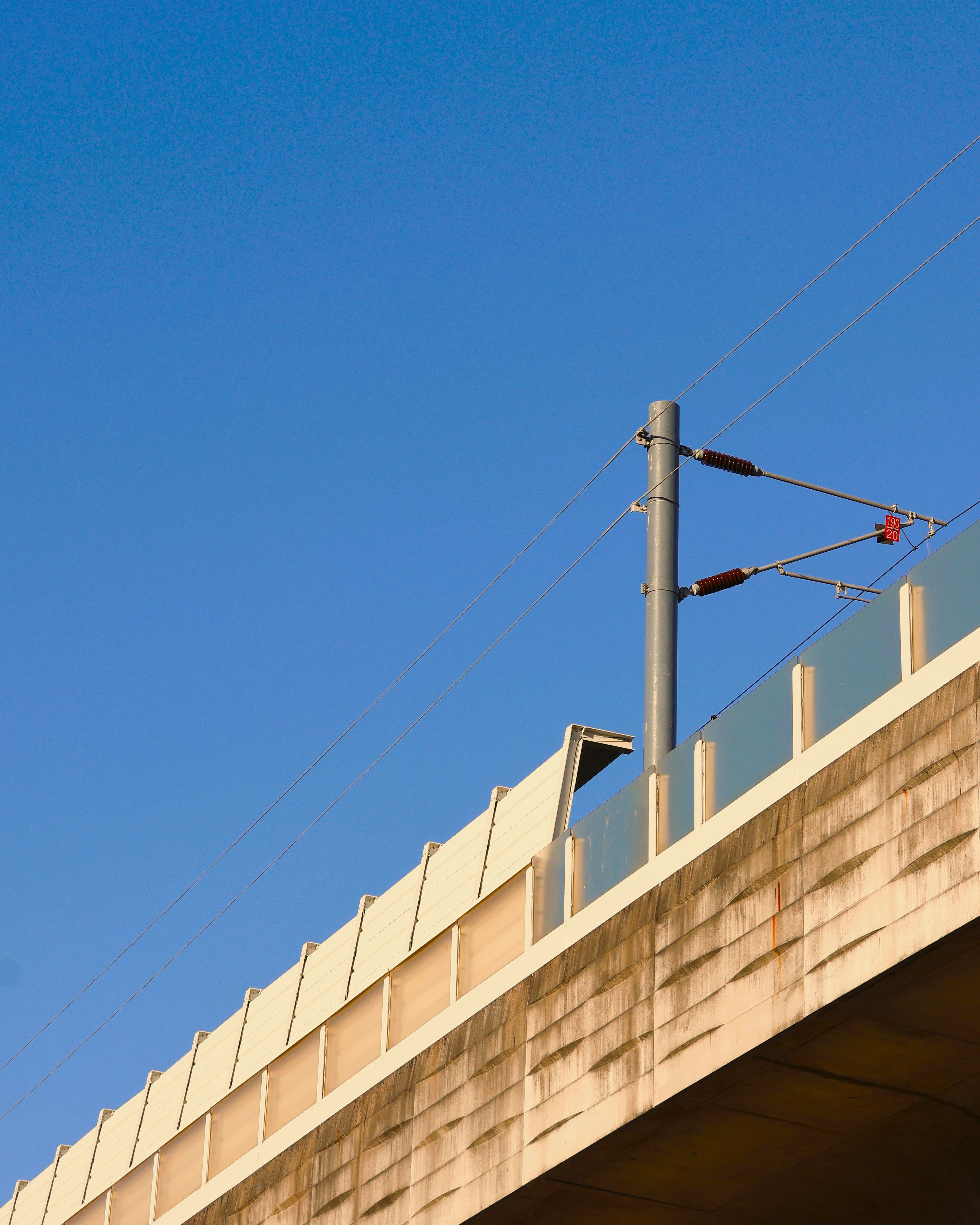 Minimalist Bridge and Power Lines Under Blue Sky · Free Stock Photo