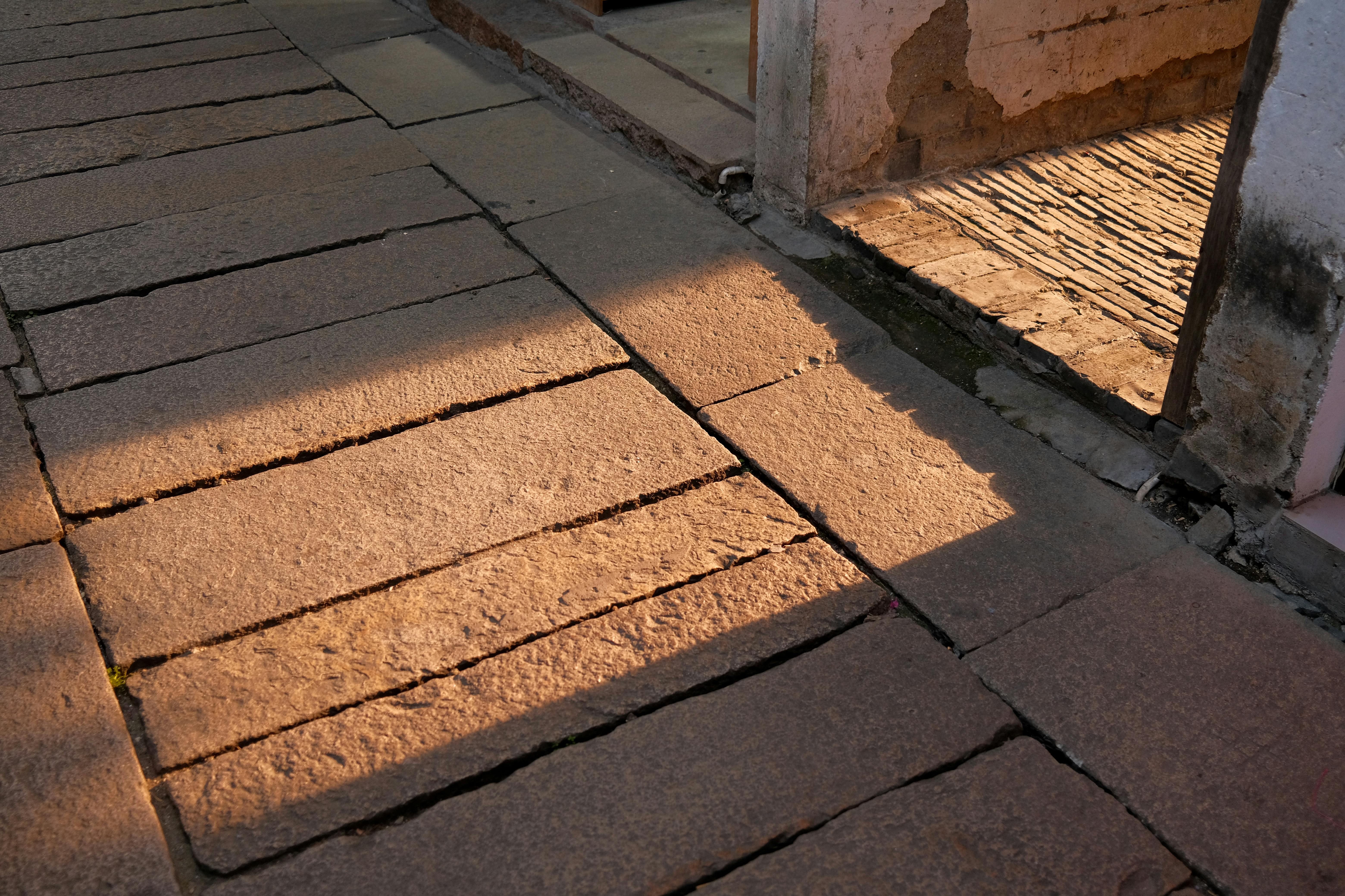 Gratis Camino de piedra iluminado por el sol en Suzhou, China, proyectando sombras dramáticas en la luz del atardecer. Foto de stock