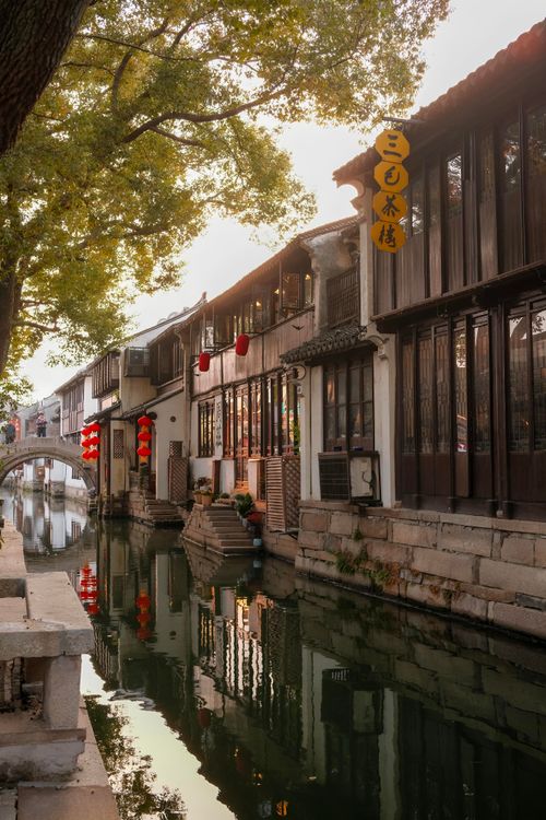 Free Charming Suzhou canal view with traditional architecture and red lanterns reflecting in the water. Stock Photo