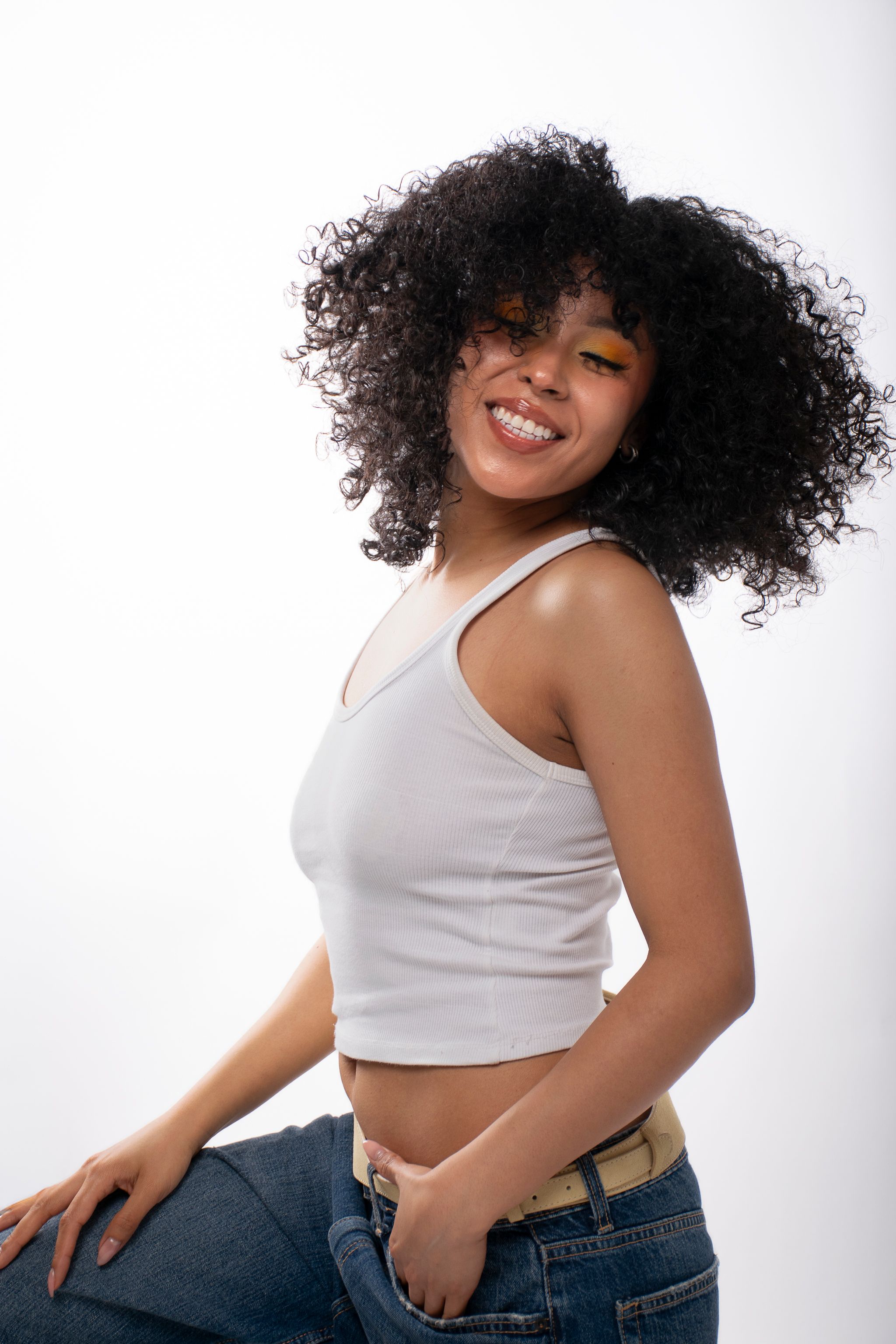 Smiling Young Woman with Curly Hair in Studio · Free Stock Photo