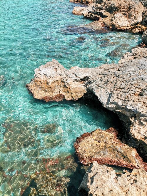 Free Stunning turquoise sea water and rocky coastline creating a serene outdoor landscape. Stock Photo