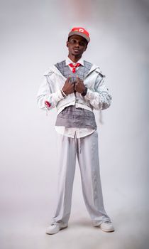 Stylish young adult in modern white outfit posing confidently indoors.