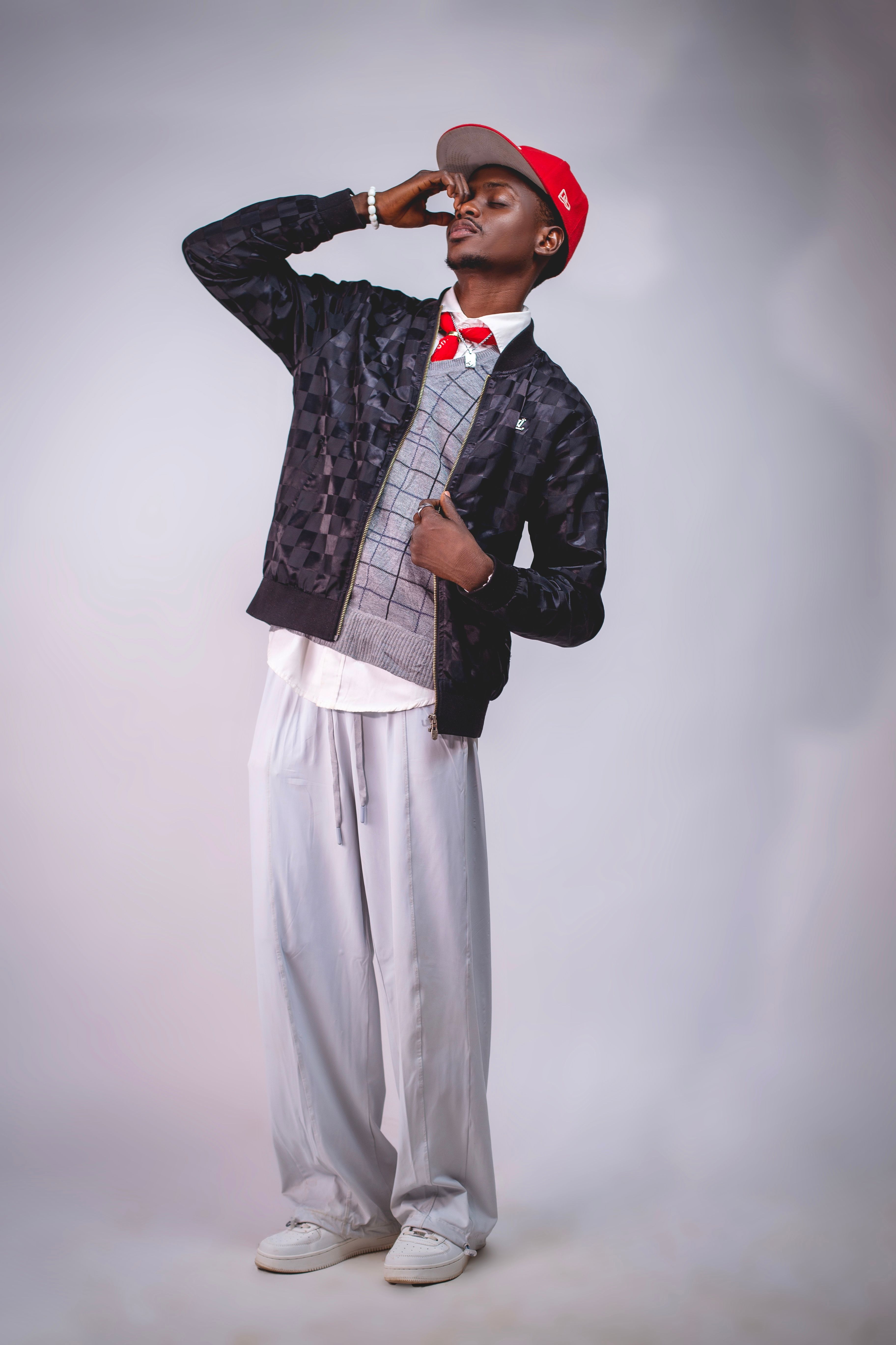 Fashionable young man posing indoors with a confident look, wearing a stylish and modern outfit.