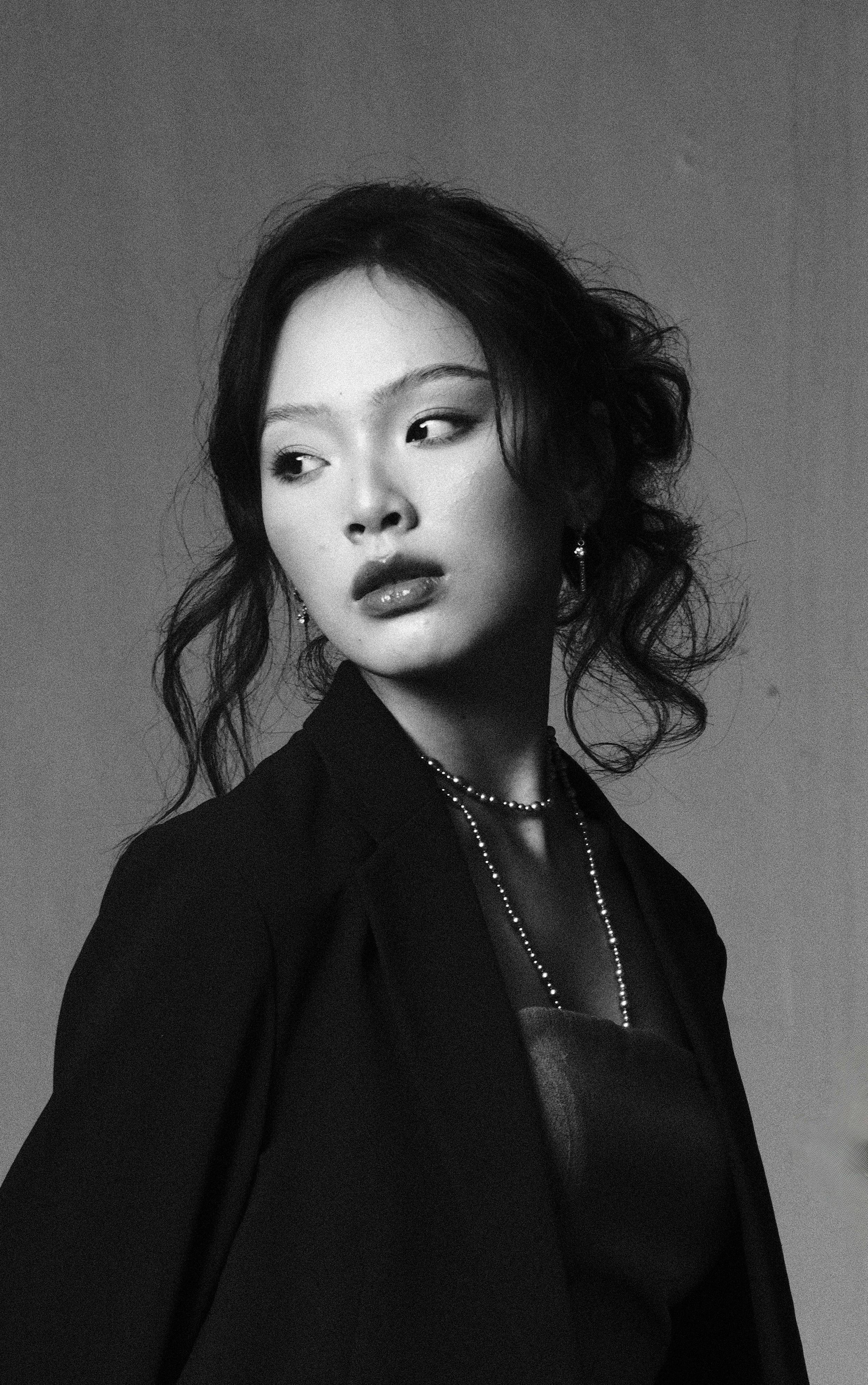 Sophisticated black and white portrait of a woman in a stylish outfit.