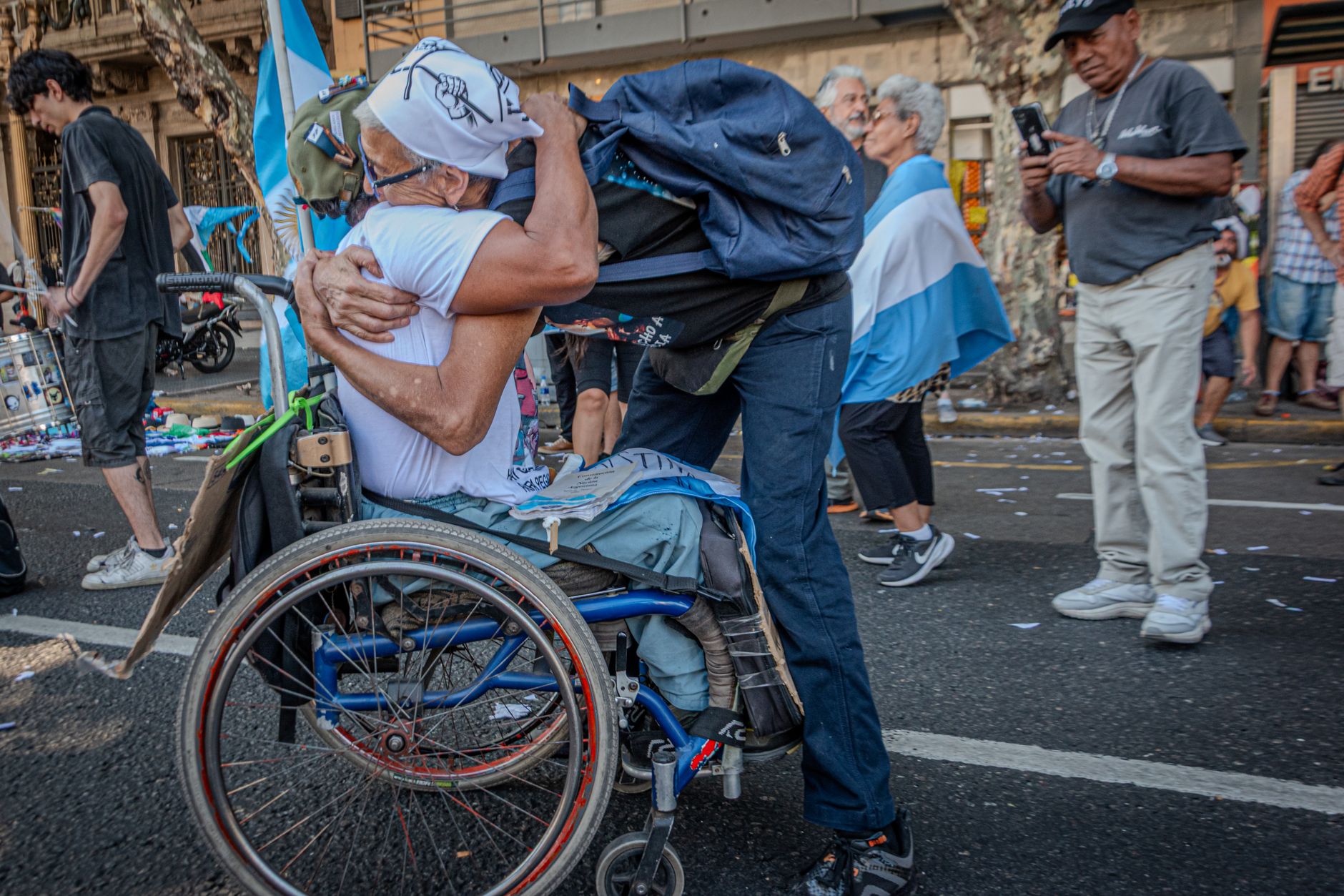 Heartfelt hug between two adults during a street protest in Buenos Aires.