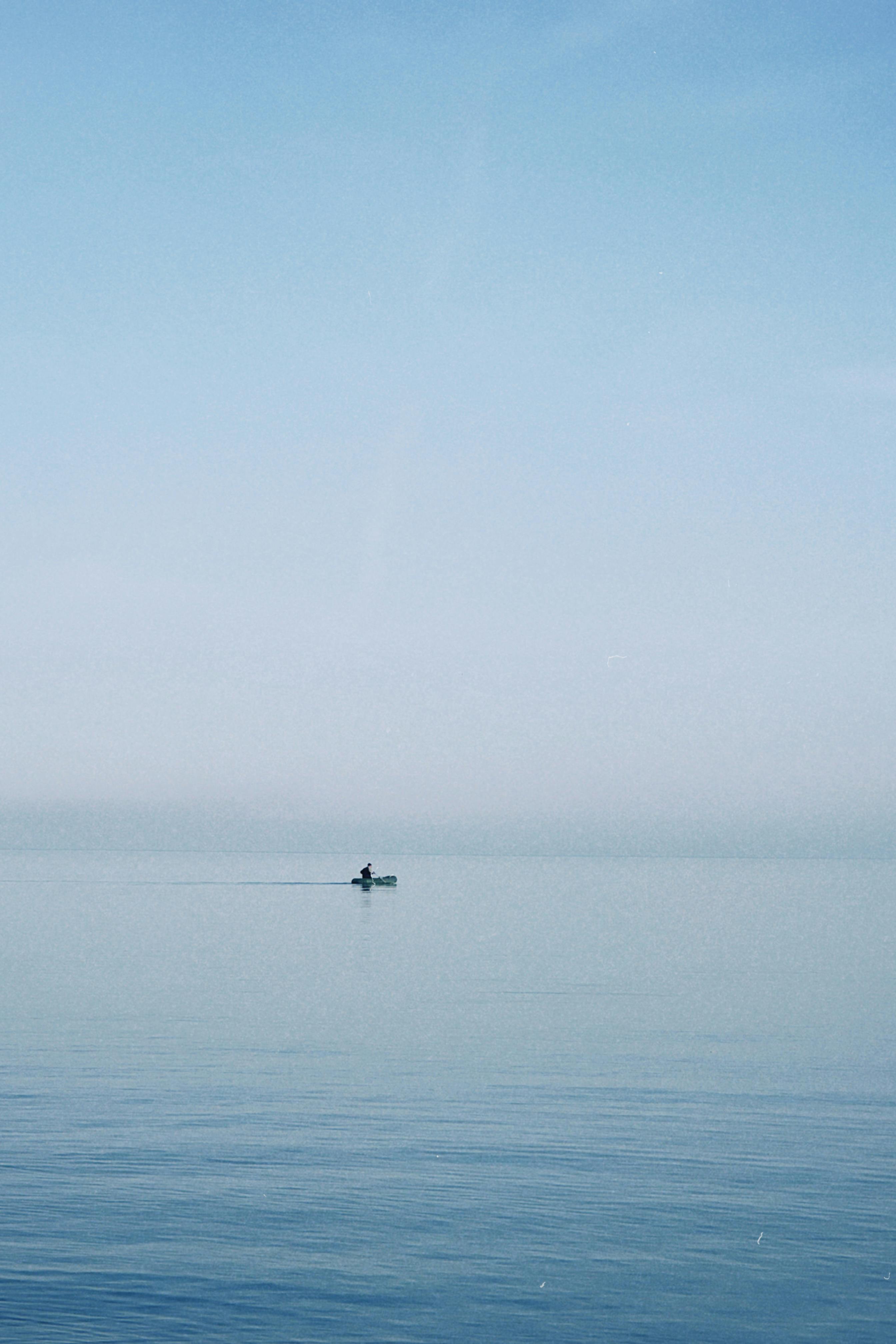 Free A lone kayaker navigates a calm lake under a clear sky in Konaev, Kazakhstan. Stock Photo
