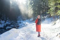 一个冬日，阳光明媚，一名妇女徒步穿越波兰扎科帕内白雪皑皑的森林