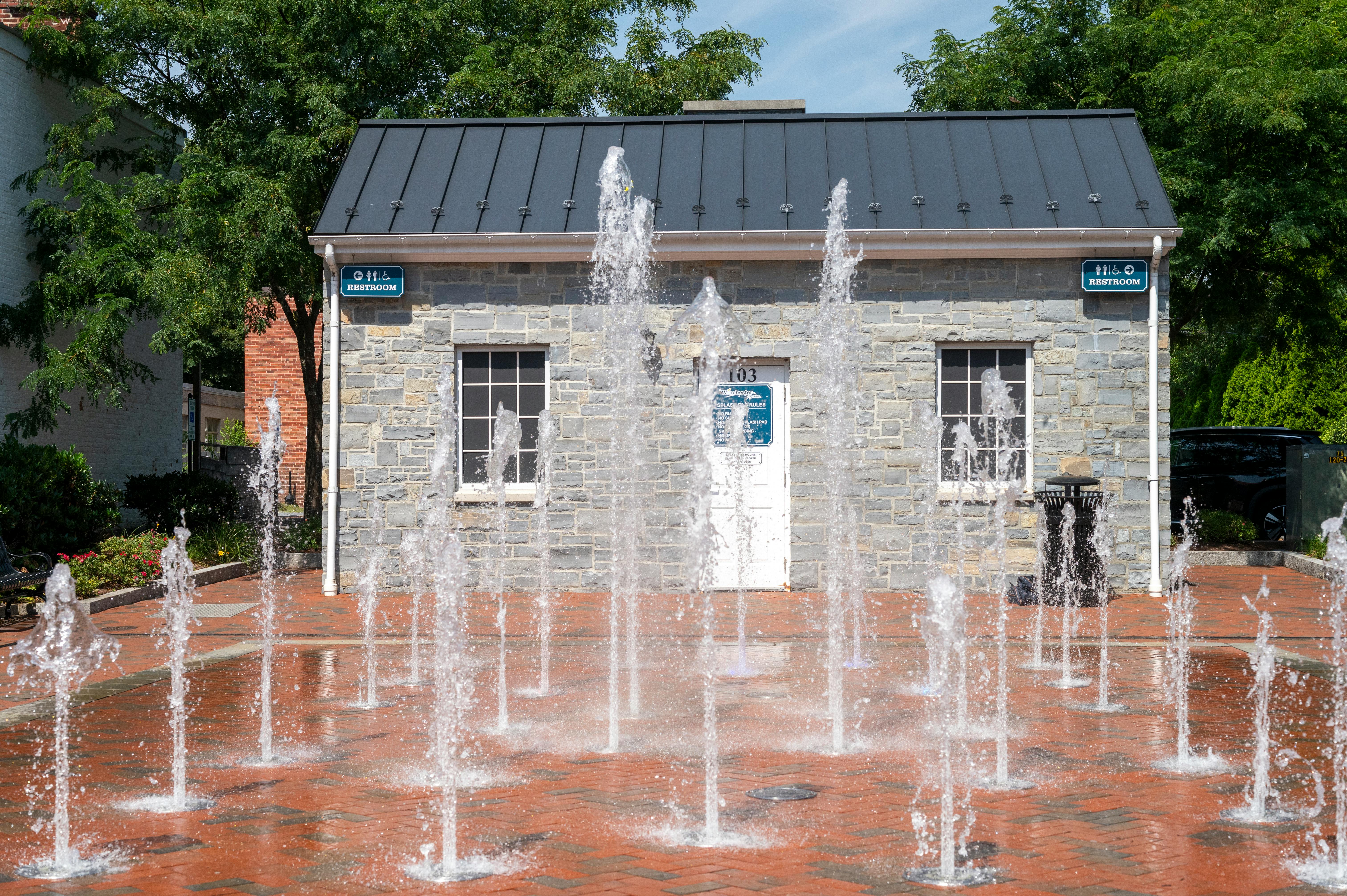 Dynamic urban park fountain splashing on a sunny day in Winchester, Virginia.