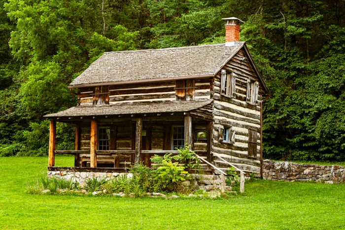 Historic log cabin surrounded by lush greenery — photo by Kristopher Hines on Pexels