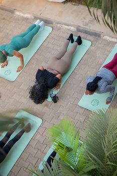 A group of adults practicing yoga outdoors in Abuja, Nigeria, from a top view.