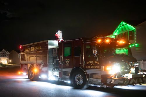 Free A decorated fire truck in Middletown displaying holiday cheer with Santa on top, illuminated at night. Stock Photo