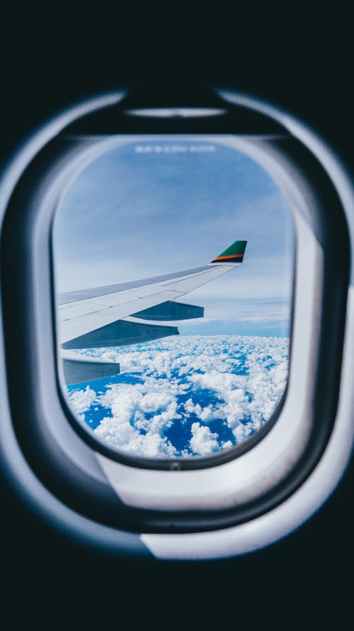 Вид из окна самолета на крыло самолета и облака