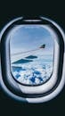 Airplane Window View of Airplane Wing and Clouds