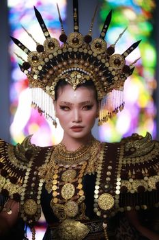 A captivating portrait of a woman in traditional Indonesian attire with intricate headdress and accessories.